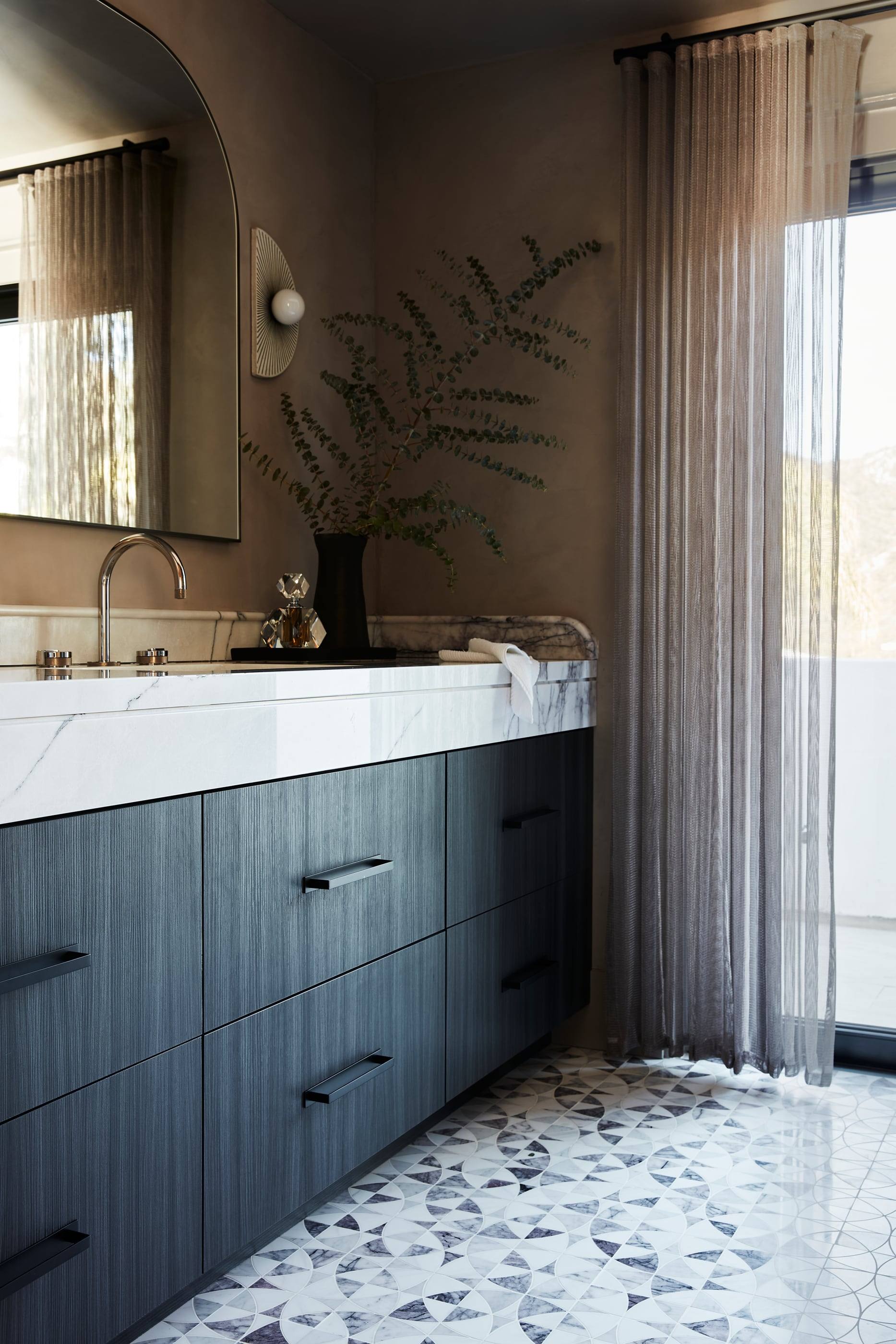 Bath with a fluted navy vanity and terrazzo floor