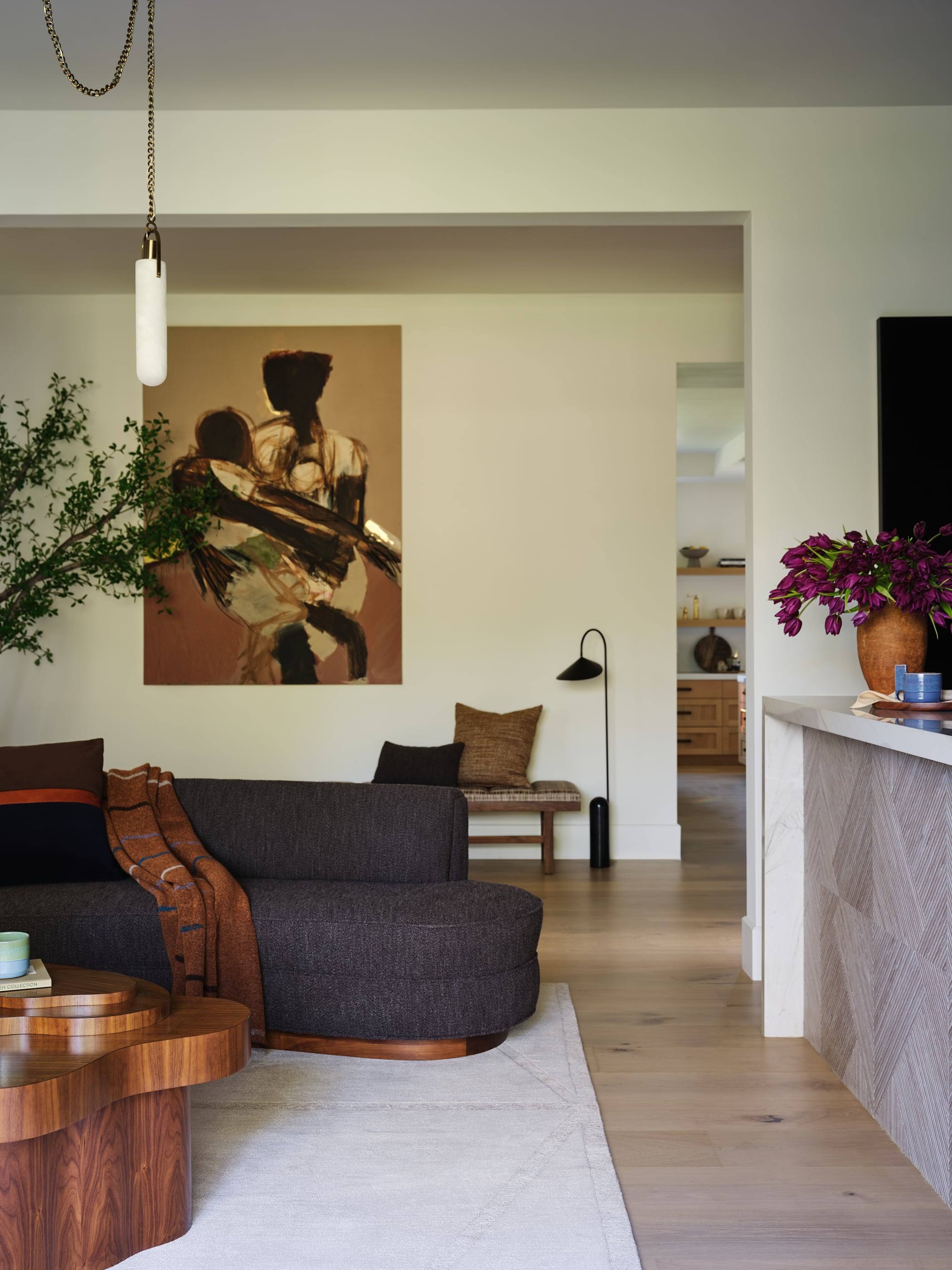 Family room opening to the kitchen beneath a large painting