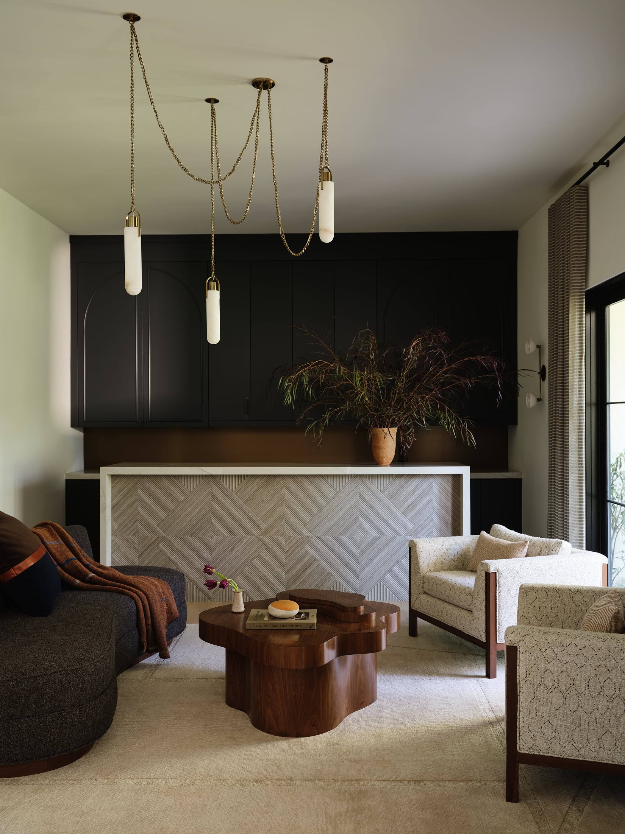 Family room with a sculptural walnut coffee table and curved sofa