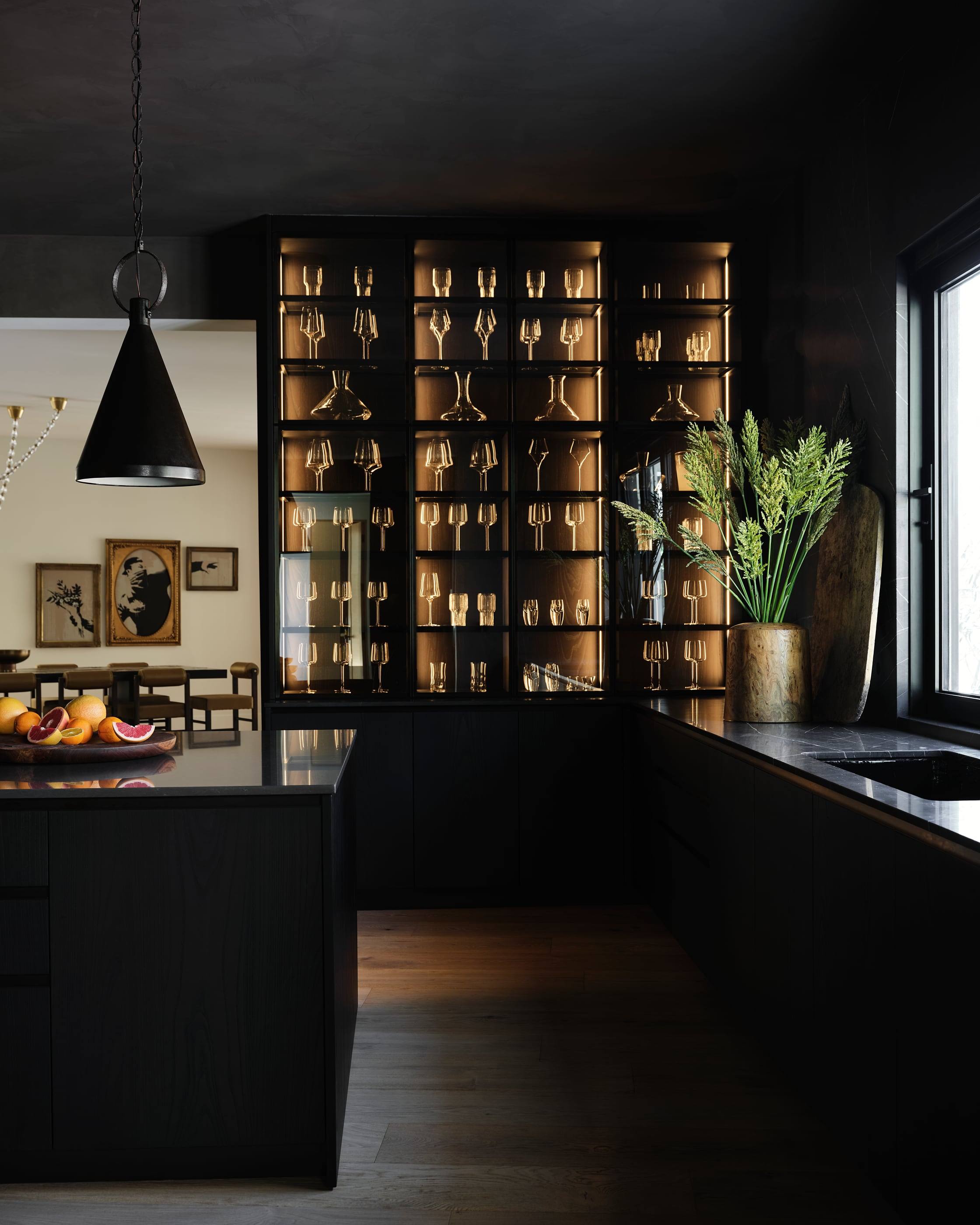 Kitchen with backlit glass cabinetry and a black island