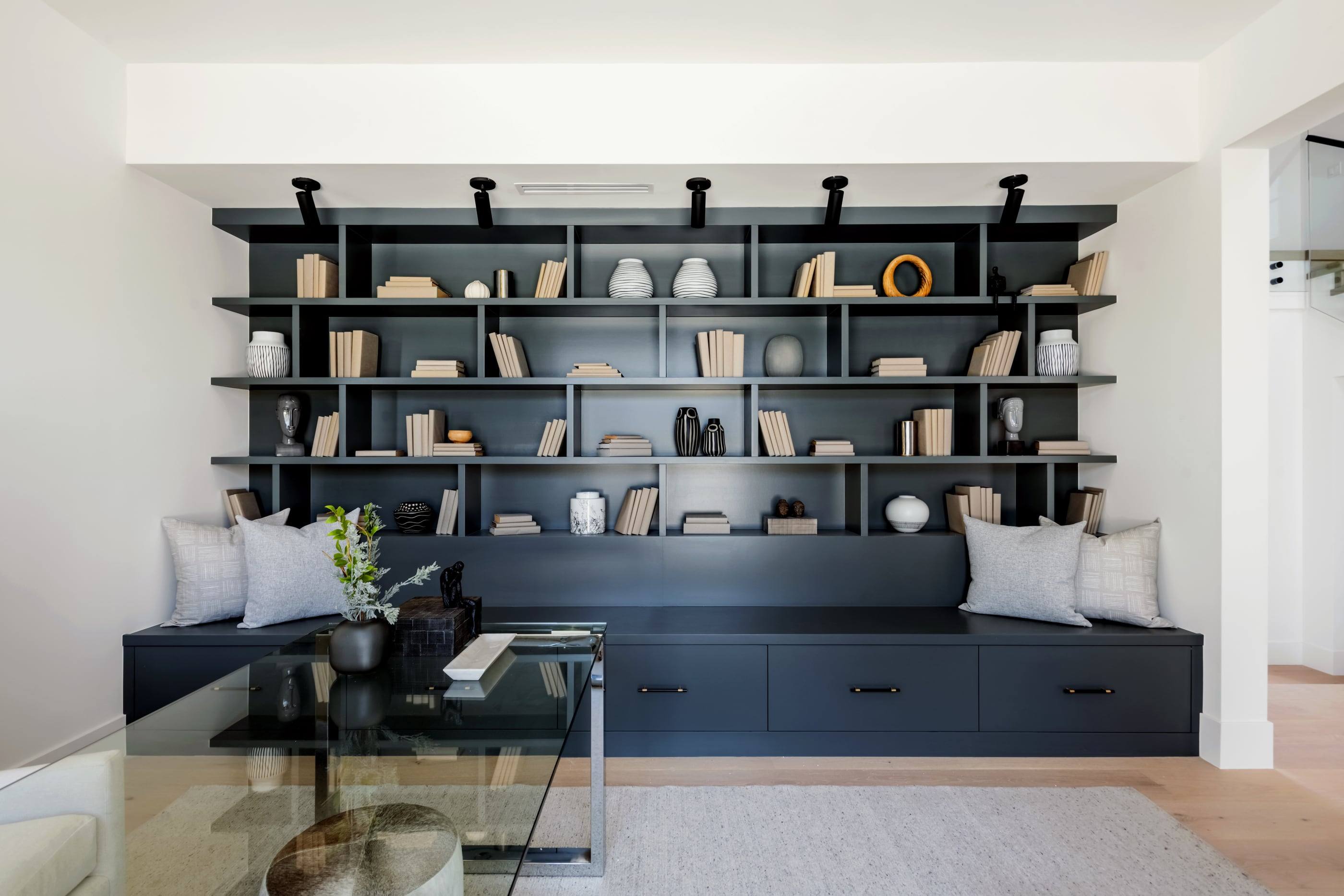 Family room with a blackened steel library wall and built-in window seat