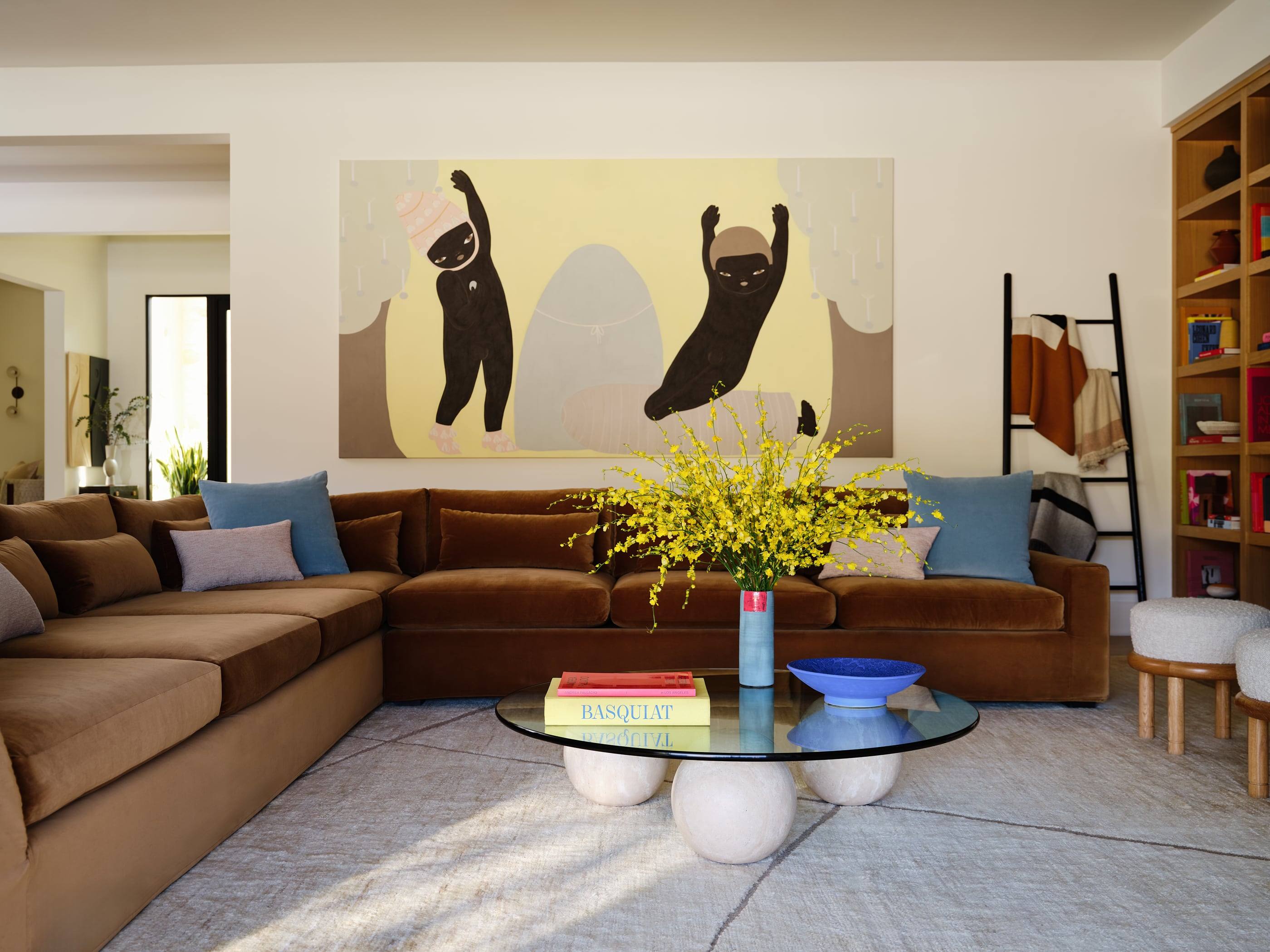 Living room with a cognac velvet sectional and a large figurative painting