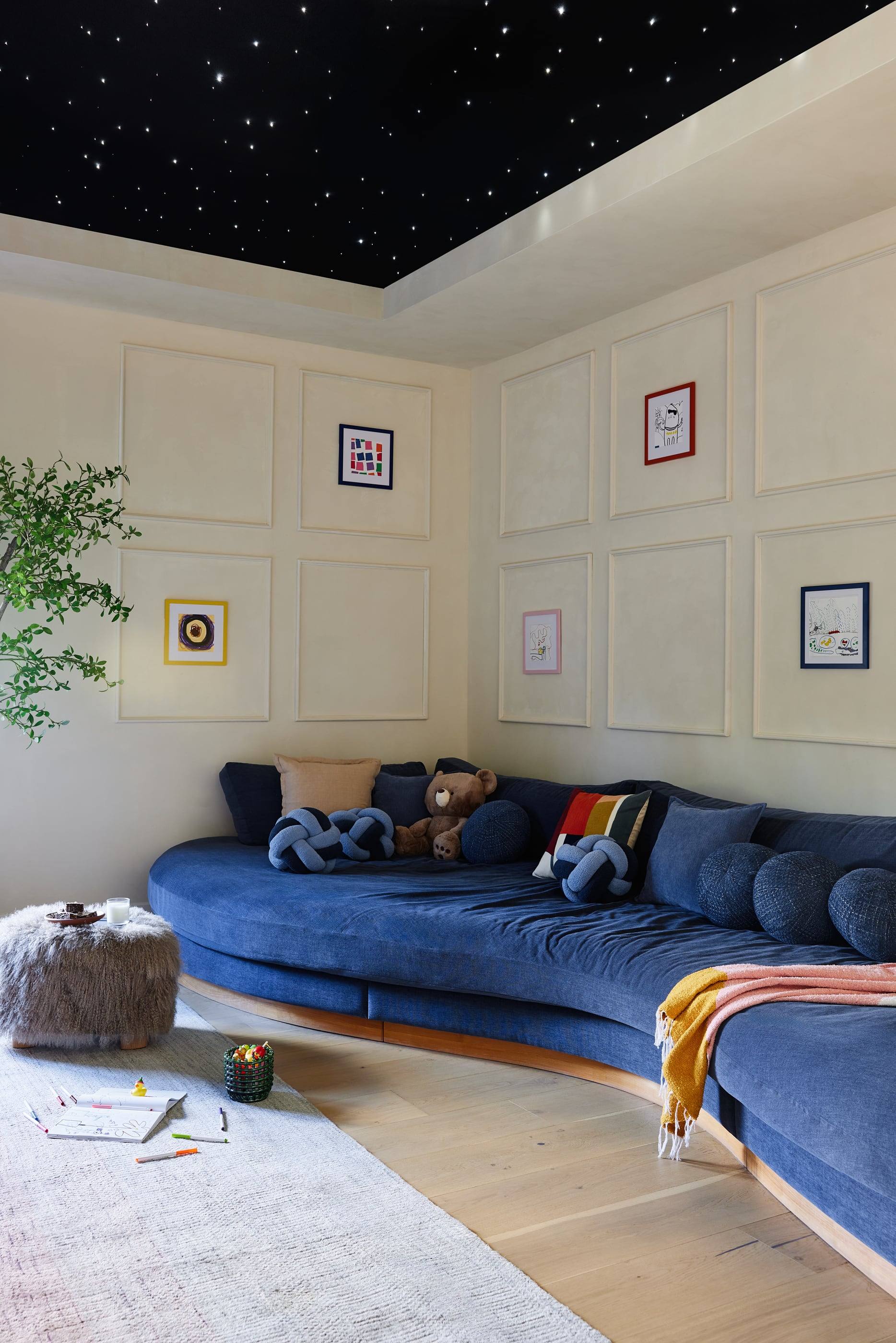 Playroom with a curved blue sofa beneath a starry ceiling