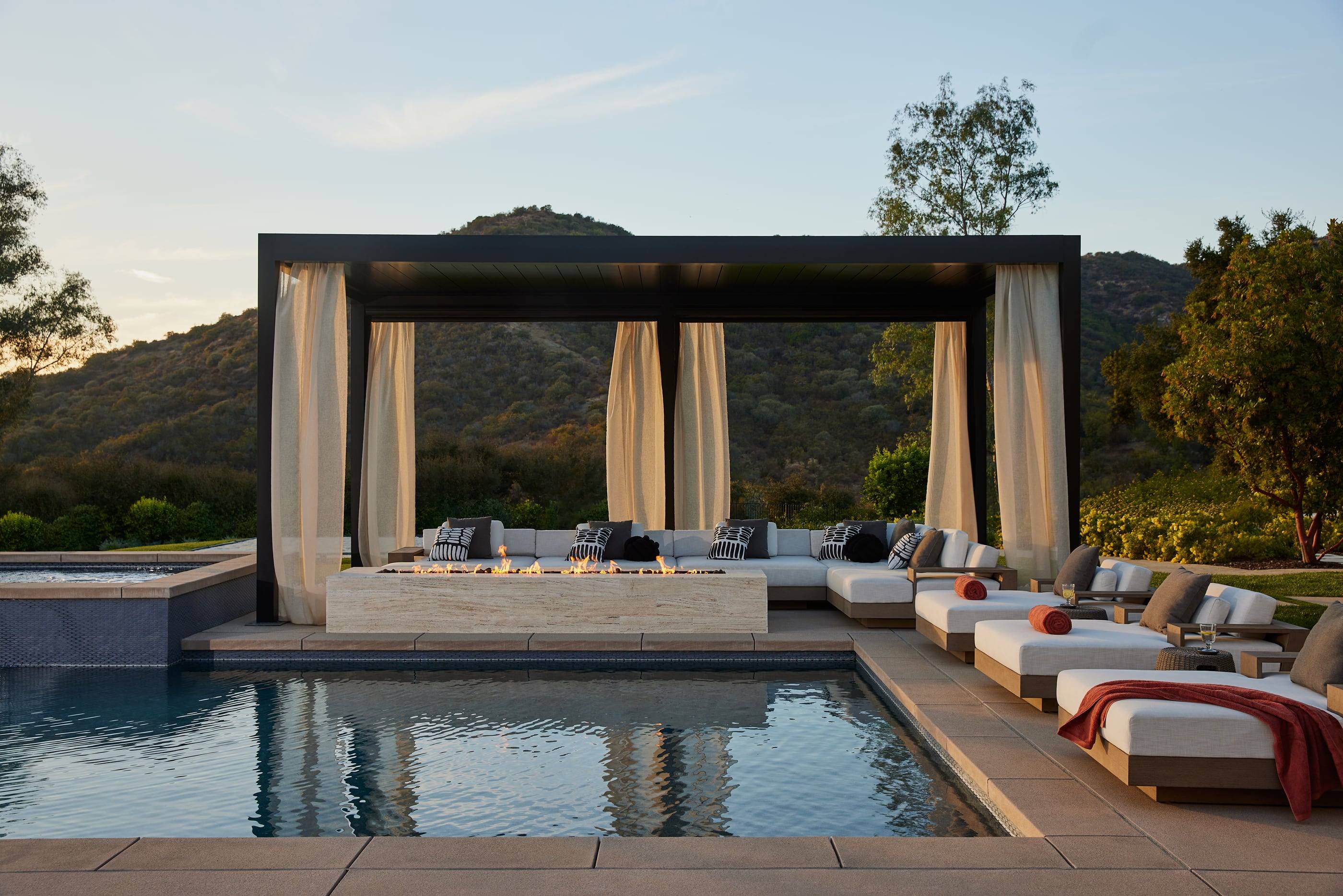 Curtained cabana and pool at golden hour with the Calabasas hills behind