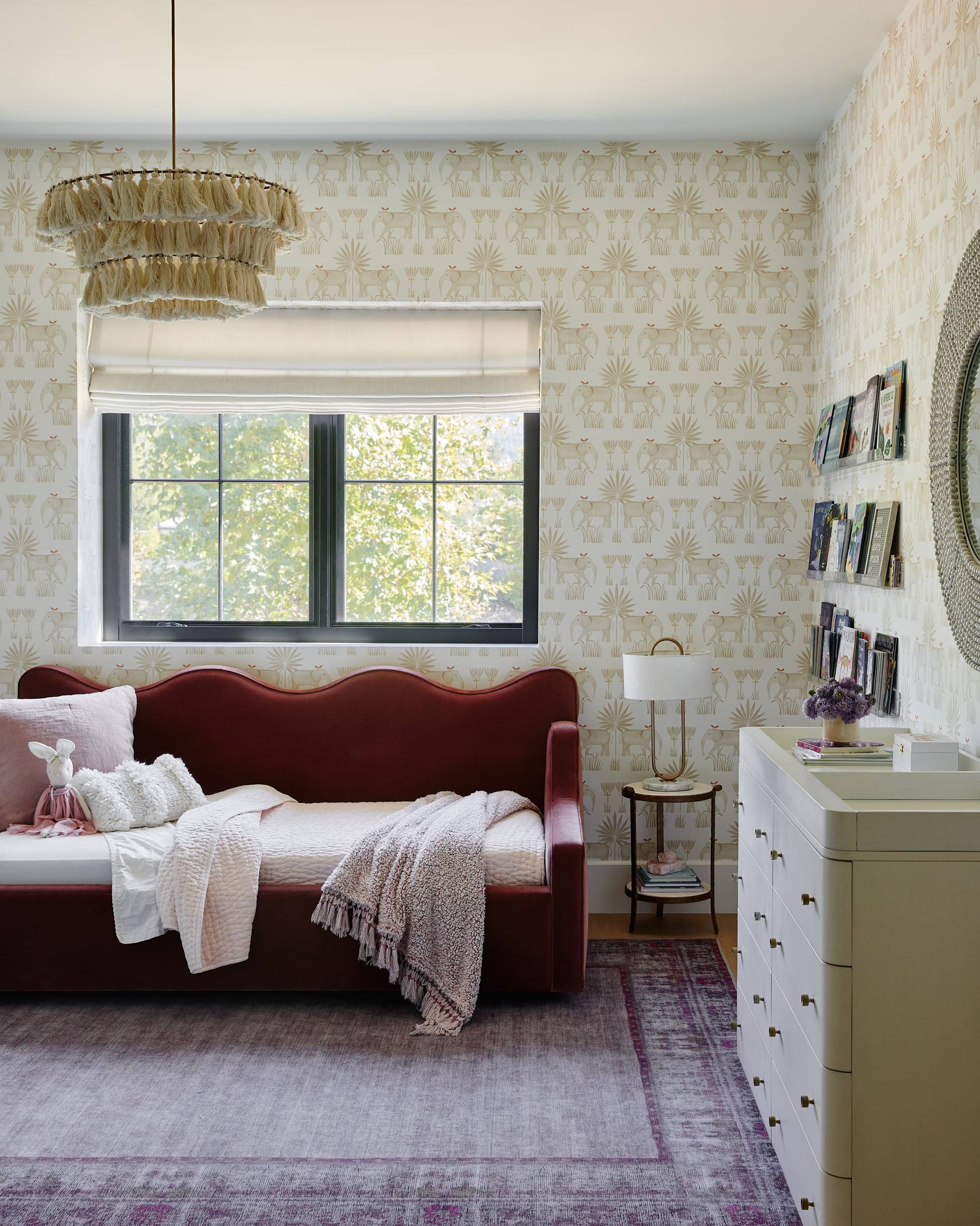 Bedroom with a scalloped velvet daybed and patterned wallpaper