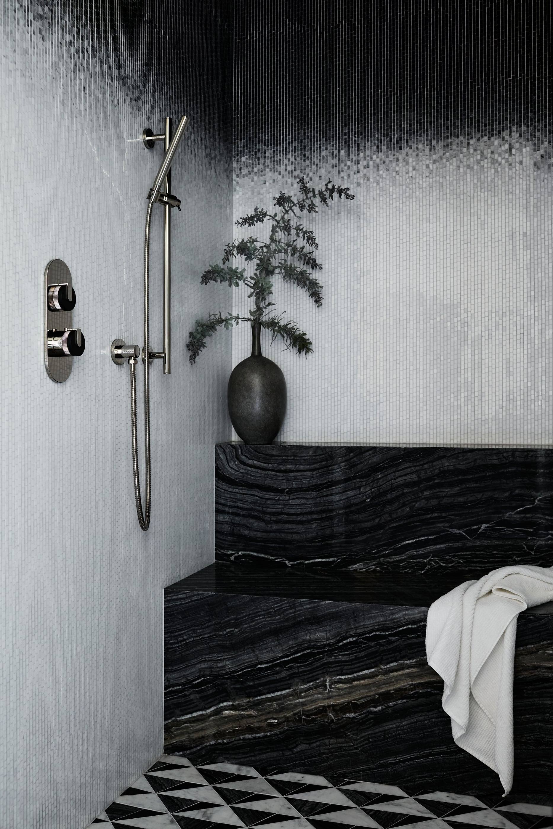 Shower in veined black marble with a patterned floor