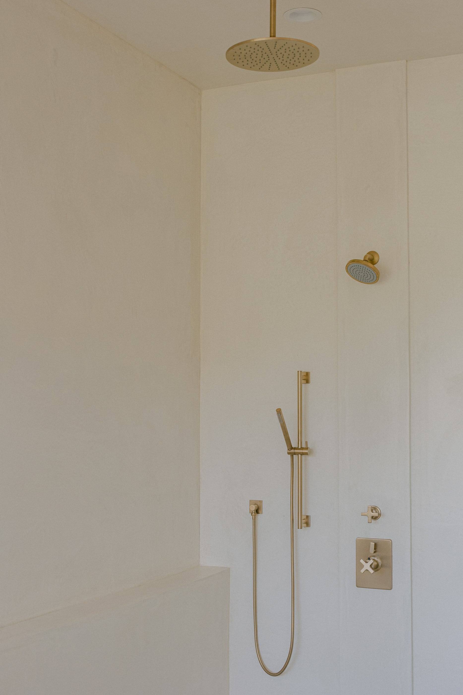 Plaster-white shower with brushed brass fittings