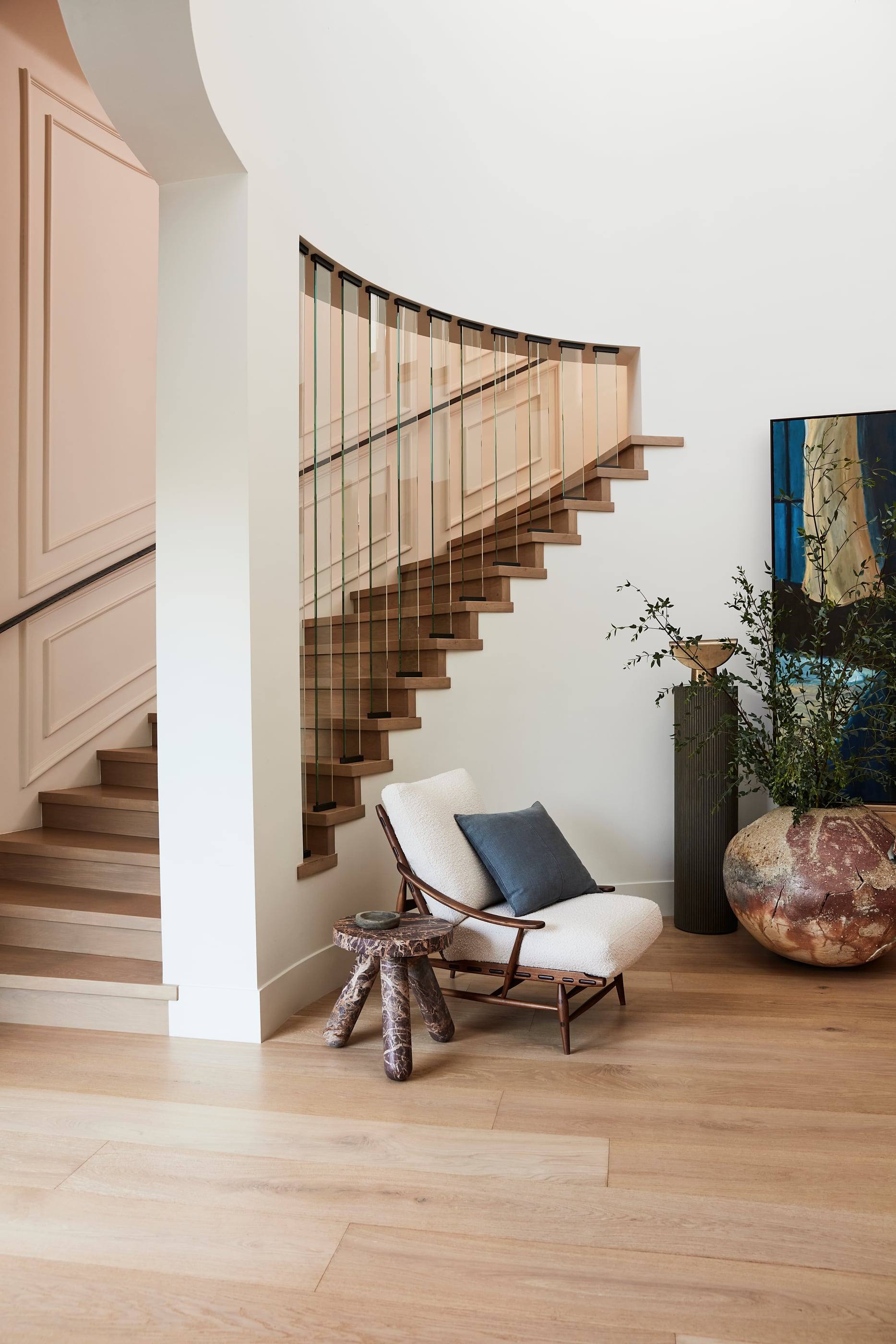 Curving oak staircase with a reading chair below