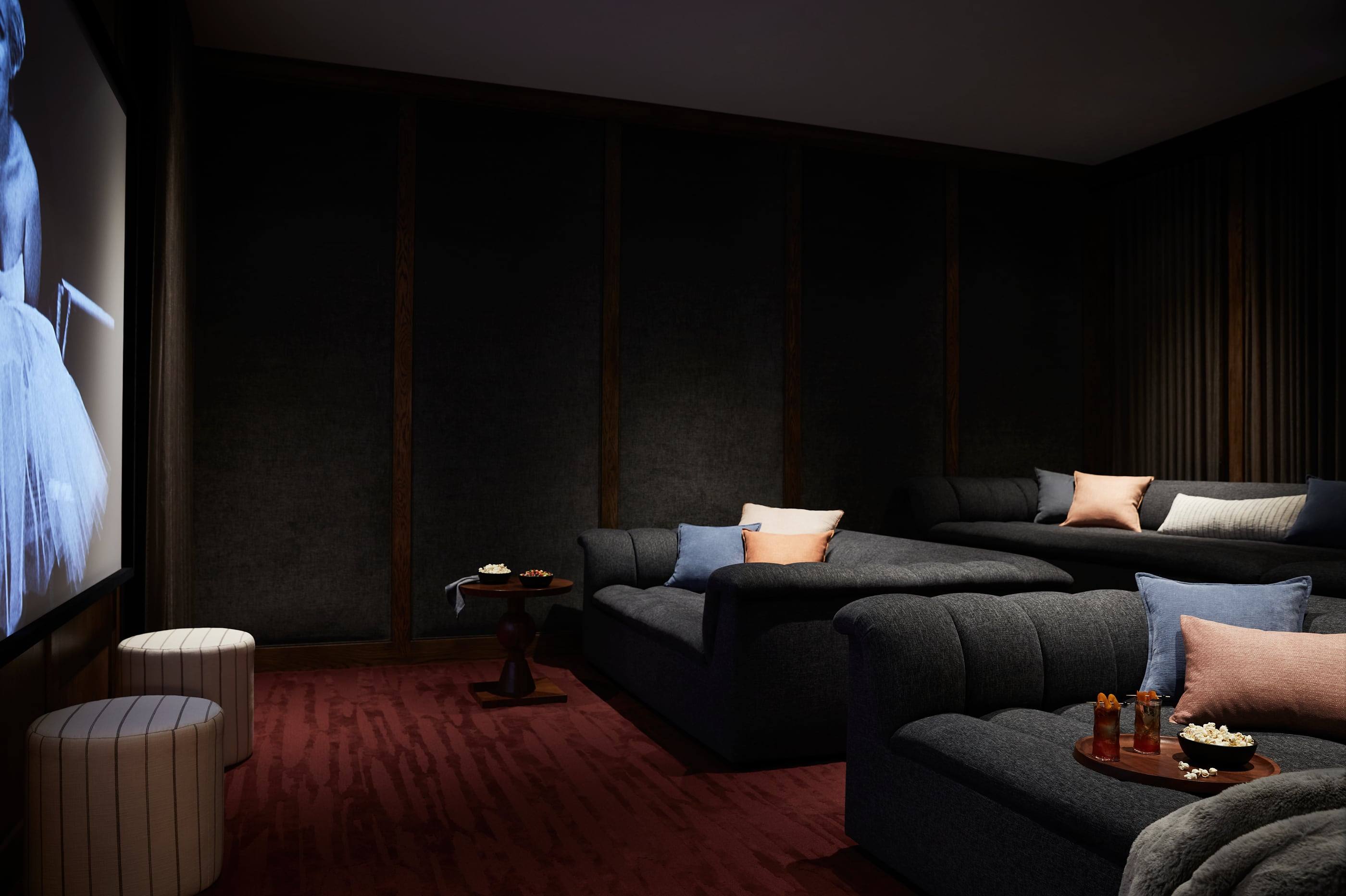 Home theater with deep sofas and a burgundy carpet