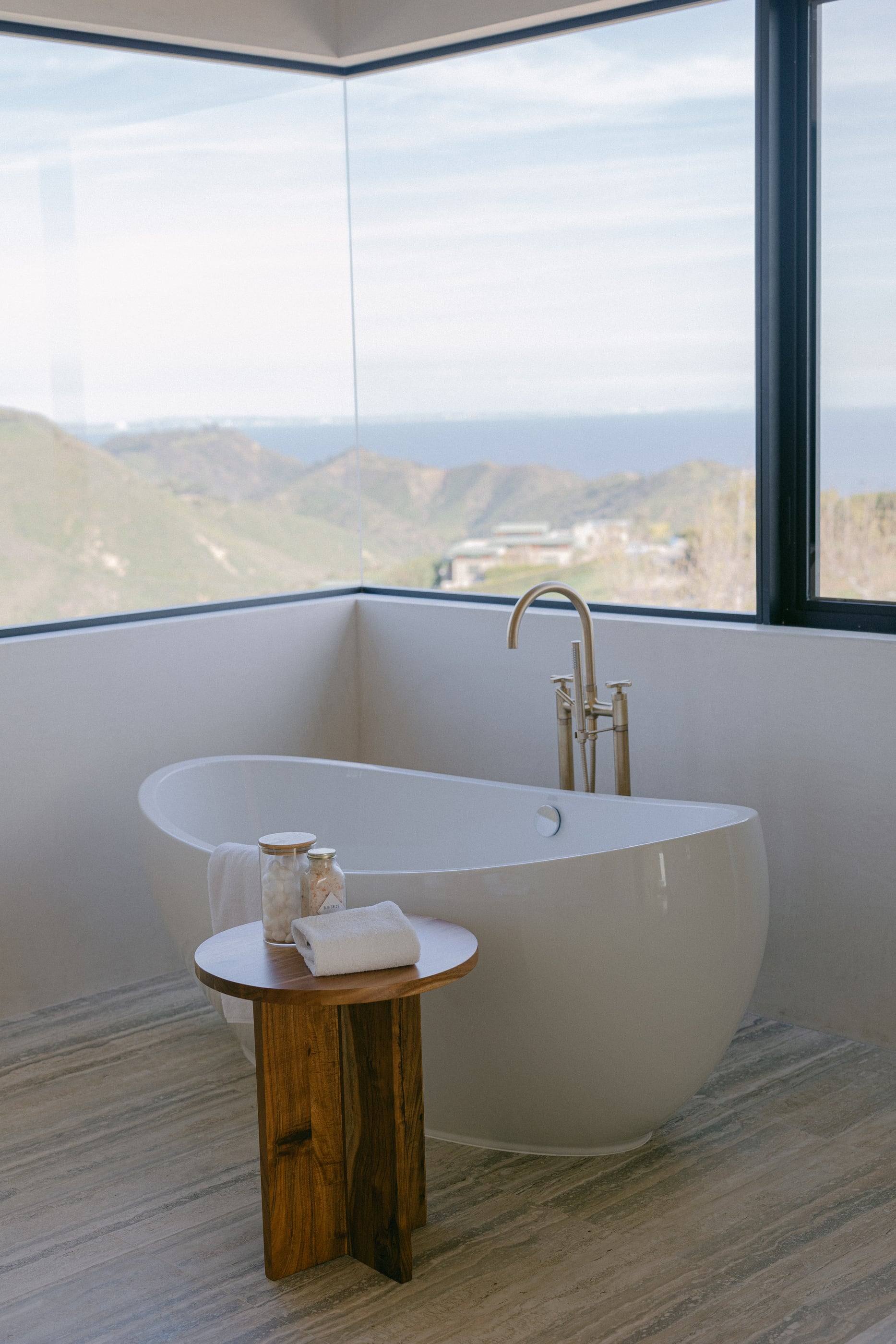 Freestanding tub in a glass corner overlooking the Malibu hills and the ocean