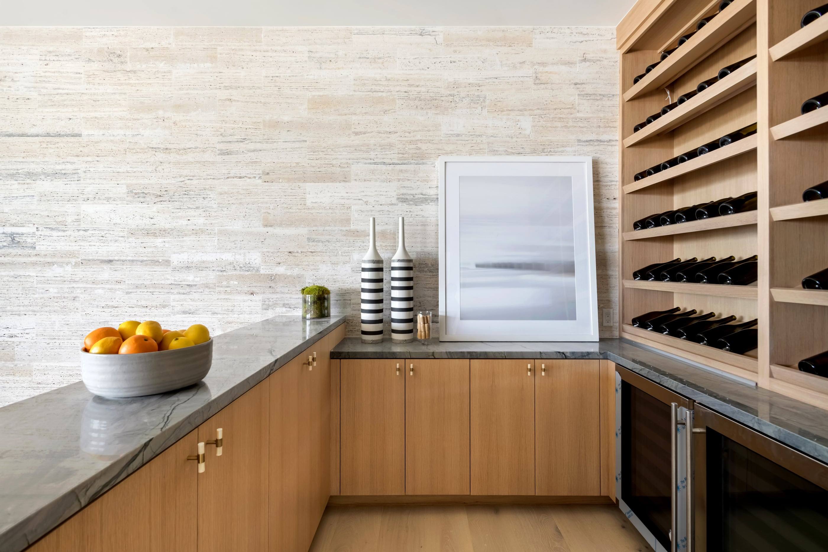 Oak wine wall beside a travertine-clad bar